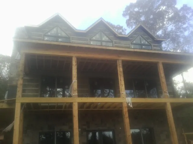 Dormers and porch framing on a large log home under construction — Roof Coating work by our crew in Mammoth Cave
